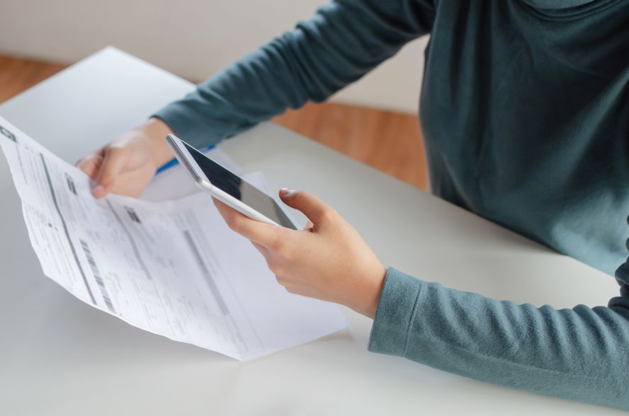 Stockfoto Rechnung mit Handy abfotografieren - Kauf auf Rechnung