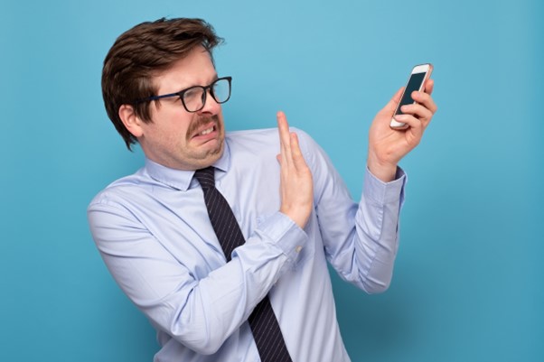 Stockfoto Man schiebt Handy von sich weg