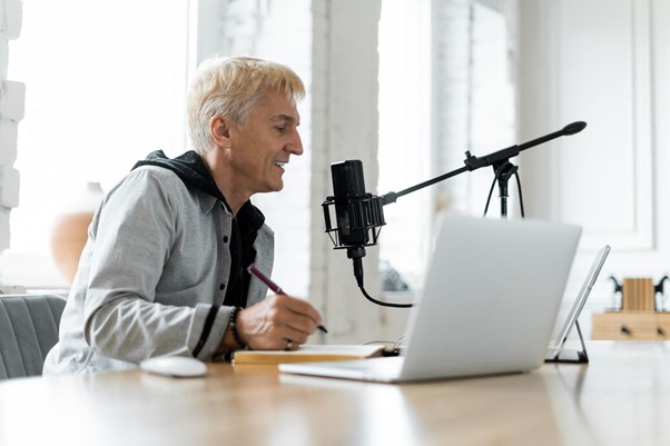 in Mitarbeiter nimmt am Laptop Content für sein Personal Branding auf.